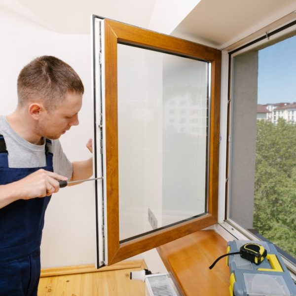 The worker installing and checking window in the house